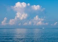 An idyllic heavenly image - a colorful balloon, with white clouds and a crescent moon over the serene sea Royalty Free Stock Photo