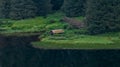 Idyllic image showcases a wooden house situated in a tranquil rural landscape in Alaska