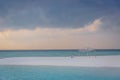 An idyllic island in Maldive in a stormy weather afternoon. Super clear water, white sand, traditional huts and tropical climate f