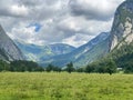Idyllic landscape in the Alps with fresh green meadows, snowcapped mountain tops in the background. Royalty Free Stock Photo