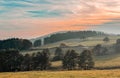 idyllic landscape like an oil painting blue sky in soft pink tones over an autumn landscape of fields and trees Royalty Free Stock Photo