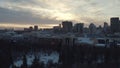 Idyllic landscape of modern city buildings, park and church at the sunset lights in winter. Action. City winter