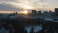 Idyllic landscape of modern city buildings, park and church at the sunset lights in winter. Action. City winter