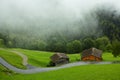 Wooden house with barn, alpine living in foggy fall landscape