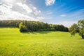 Scenic panoramic view of idyllic rolling hills landscape with blooming meadow, beautiful sunny day with blue sky and clouds Royalty Free Stock Photo