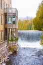 Idyllic natural landscape, waterfall of a river near building with balconies