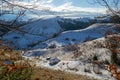 Idyllic panoramic landscape in Magura, Brasov, Romania, on an early morning, late autumn day, with isolated houses on snowy hills