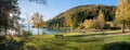 Idyllic picnic area at lake shore Walchensee, Jachenau. evening scenery with golden lighted trees in autumn Royalty Free Stock Photo