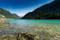 Idyllic and picturesque turquoise mountain lake surrounded by green forest and mountain peaks in the Swiss Alps