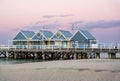 Idyllic pier extending out into a body of water at sunset, with charming cottages, Busselton Jetty