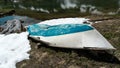 Idyllic pristine mountain lake with a broken boat on the shore and snow fields