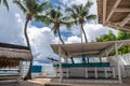 Idyllic restaurant on the beach with wooden tables and benches and white umbrellas