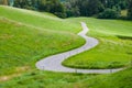 An idyllic road between green fields in the mountains