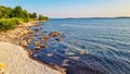 Idyllic rocky beach in tourist coastal town Medulin, Istria peninsula, Croatia, Europe. Panoramic view of rugged coastline Royalty Free Stock Photo