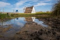 Idyllic rural landscape with small shelter house reflected in the water, with wooden bridge and surrounded by vegetation