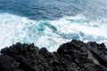 Idyllic scene of clear blue sea crashing against volcanic black rocks at cliffs of Terceira Island, Azores.
