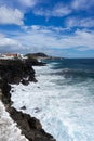 Idyllic scene of clear blue sea crashing against volcanic black rocks at cliffs of Terceira Island, Azores.