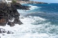 Idyllic scene of clear blue sea crashing against volcanic black rocks at cliffs of Terceira Island, Azores.