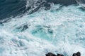 Idyllic scene of clear blue sea crashing against volcanic black rocks at cliffs of Terceira Island, Azores.