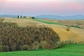 Idyllic scenery of a lovely church Chapel of Our Lady of Vitaleta standing on a hillside at rosy dusk with cultivated farmlands