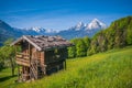 Idyllic springtime landscape in the Alps with traditional mountain cottage Royalty Free Stock Photo