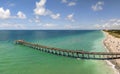 Idyllic summer day over sandy beach at Venice fishing pier in Florida. Summer seascape with surf waves crashing on sea