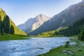 Idyllic summer landscape with hiking trail in the mountains with river with reflection and forest. Royalty Free Stock Photo