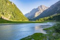 Idyllic summer landscape with hiking trail in the mountains with river with reflection and forest. Royalty Free Stock Photo