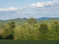 Idyllic summer landscape of lucitian mountains, with lush green grass meadow, fresh deciduous and spruce tree forest, hills and Royalty Free Stock Photo