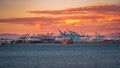 Idyllic sunset view of a harbor with multiple ships on the distant horizon in Long Beach, USA.