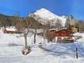 Idyllic Swiss alpine mountain huts and traditional Swiss rural architecture dressed in winter clothes and in a fresh snow cover