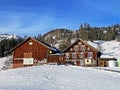 Idyllic Swiss alpine mountain huts and traditional Swiss rural architecture dressed in winter clothes and in a fresh snow cover