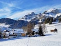 Idyllic Swiss alpine mountain huts and traditional Swiss rural architecture dressed in winter clothes and in a fresh snow cover