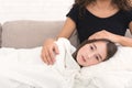 Sad girl lying on mother`s knees on sofa Royalty Free Stock Photo