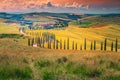 Idyllic Tuscany landscape at sunset with curved rural road, Italy