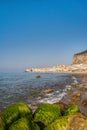 Idyllic view of Cefalu from the long sandy beach. Cathedral and Rocca di Cefalu rocky mountain on a sunny day in Cefalu, Sicily,