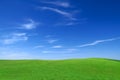 Idyllic view, green field and the blue sky with white clouds Royalty Free Stock Photo