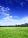 Idyllic view, green hills and blue sky with white clouds Royalty Free Stock Photo