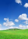 Idyllic view, green hills and blue sky with white clouds Royalty Free Stock Photo