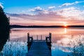 Idyllic view of the long pier with wooden bench on the lake. Sunset or sunrise over the water Royalty Free Stock Photo