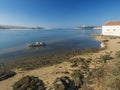 Idyllic view of the mouth of Mira river flowing into the Atlantic Ocean with small beach house and anchored fishing boat