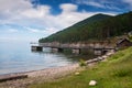 Idyllic view of the wooden pier in the lake with mountain scenery background. Lake Baikal in the day. Royalty Free Stock Photo