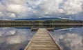 Idyllic view of a wooden pier in the lake with mountain scenery background in cloudy morning Royalty Free Stock Photo