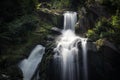 Idyllic waterfall falls into a dark gorge. Royalty Free Stock Photo
