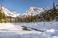 Sunny winter landscape in the alps: Mountain range, river, snowy trees, sunshine and blue sky Royalty Free Stock Photo