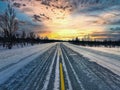 Idyllic winter scene featuring a long and desolate road surrounded by a forest