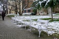 Idyllic winter scene featuring a row of wooden benches blanketed in a layer of freshly-fallen snow