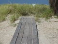 Idyllic wooden walkway leads across the golden sand of a beach
