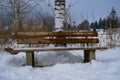 Idyllically located wooden bench in snow-covered landscape Royalty Free Stock Photo