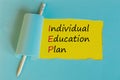 IEP individual education plan symbol. Concept words IEP individual education plan on text appearing behind torn paper. pastel blue